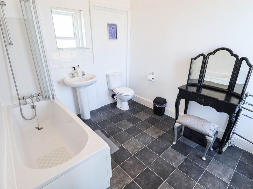 A bathroom with a bathtub, sink, toilet, and vanity at The Skegness Hotel in Skegness