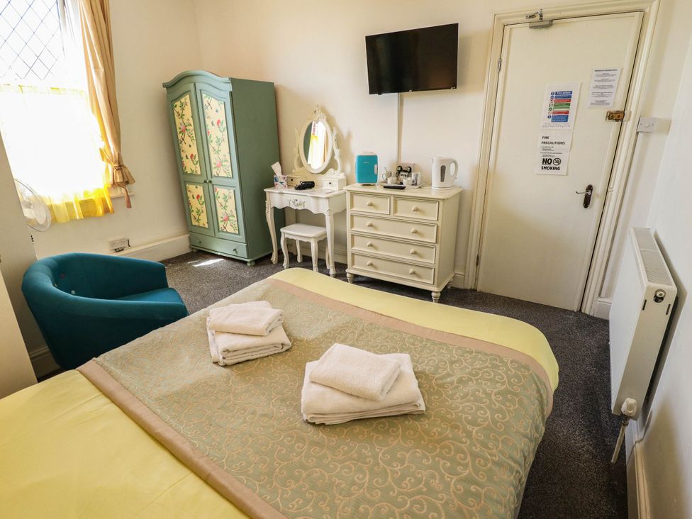 A bedroom with a bed and a wardrobe at The Skegness Hotel in Skegness