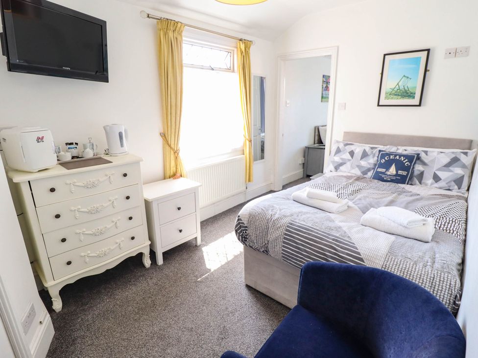 A bedroom with a bed and dresser at The Skegness Hotel in Skegness
