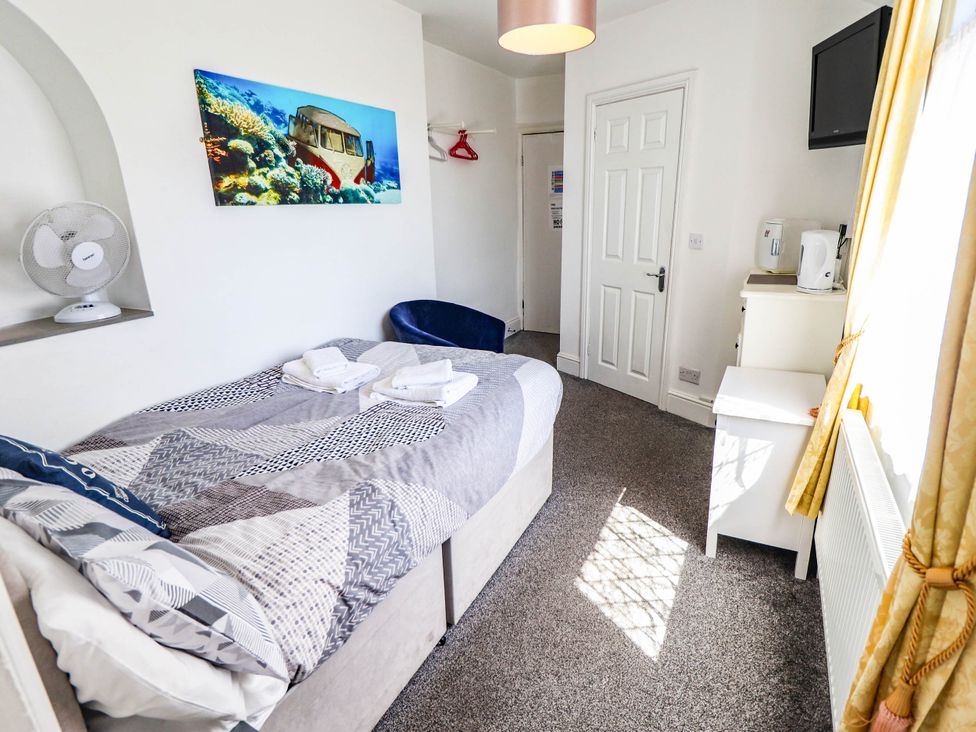 A bedroom with a bed and fan at The Skegness Hotel in Skegness