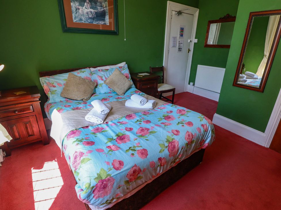 A bedroom with a bed and nightstands at The Skegness Hotel in Skegness