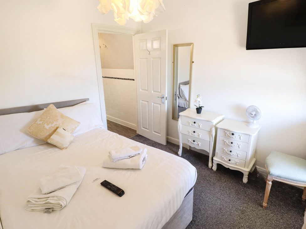 A bedroom with a bed and dresser at The Skegness Hotel in Skegness