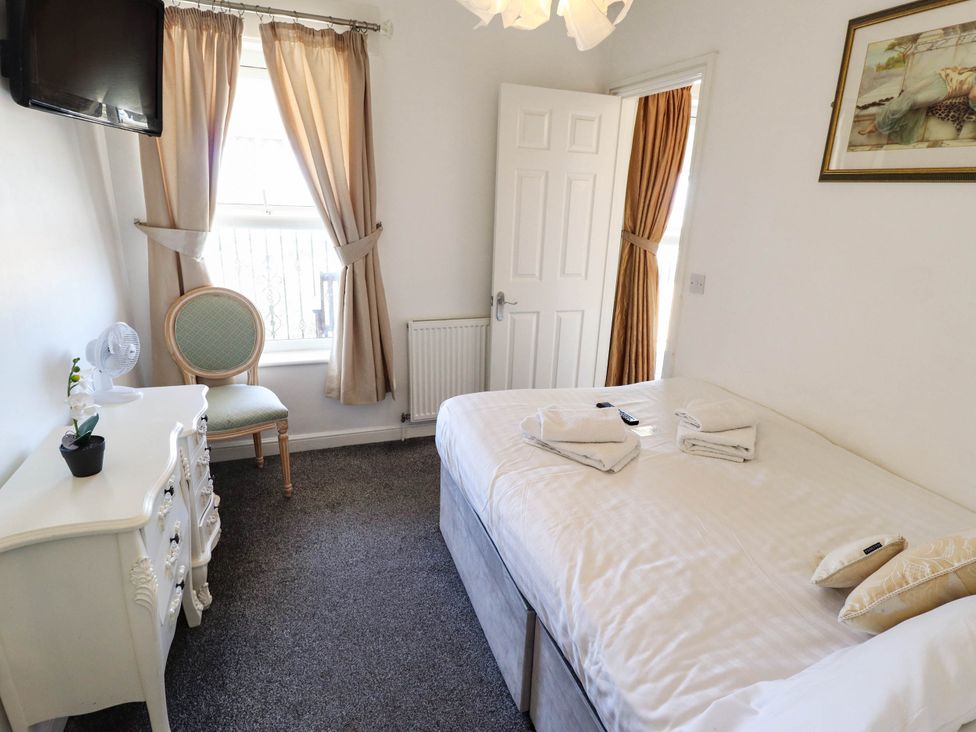 A bedroom with a bed and chair at The Skegness Hotel in Skegness