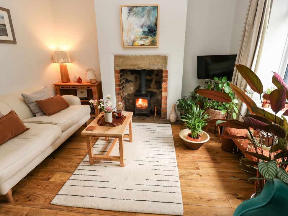 A living room with a fireplace and plants at 10 Park Road
