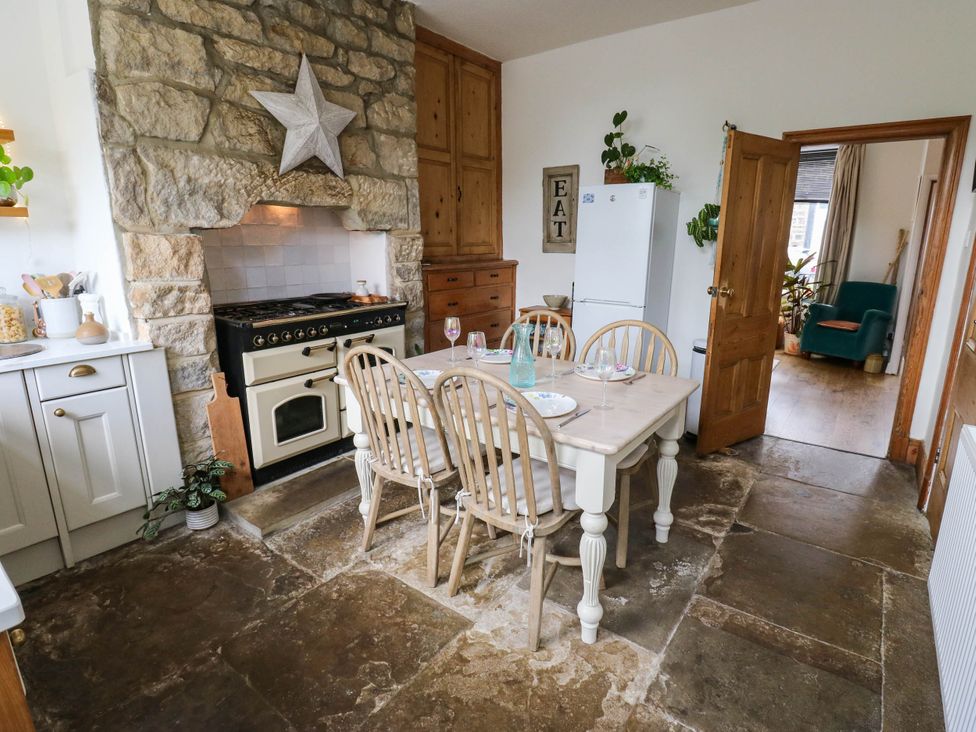 A kitchen with stone walls and a dining table at 10 Park Road