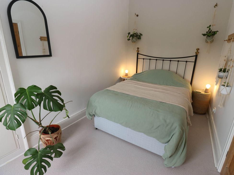 A bedroom with a bed and plants at 10 Park Road