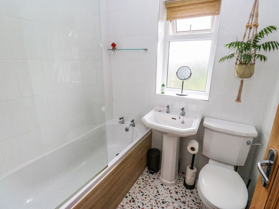 A bathroom with a bathtub, sink, and toilet at 10 Park Road in Cowling