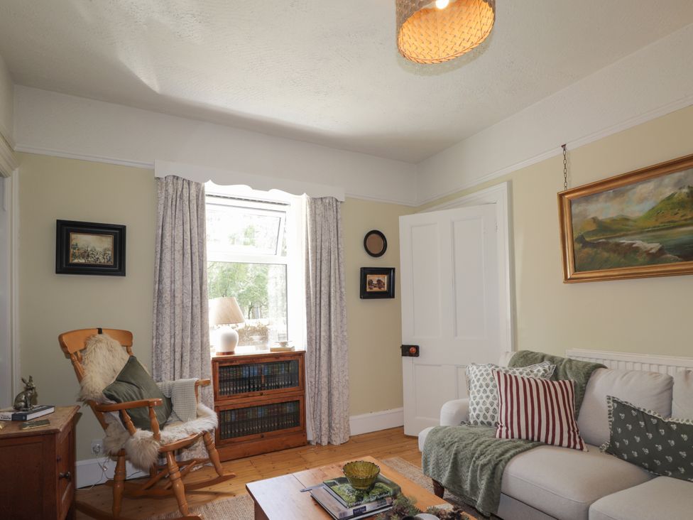 A living room with a sofa and a rocking chair at Gairnshiel School House near Ballater