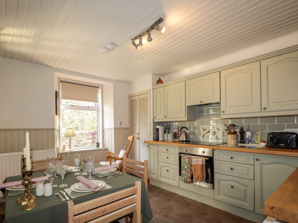 A kitchen with a dining table and chairs at Gairnshiel School House near Ballater