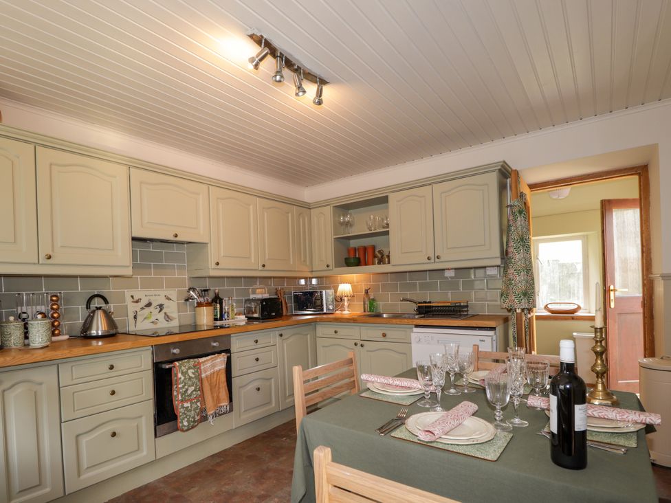 A kitchen with wooden countertops and a dining table at Gairnshiel School House near Ballater
