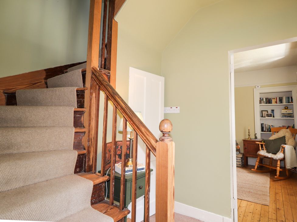 A hallway with stairs and a door at Gairnshiel School House near Ballater