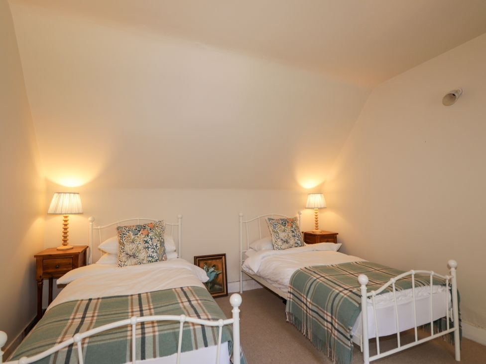 A bedroom with two beds and nightstands at Gairnshiel School House near Ballater