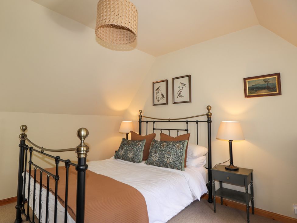 A bedroom with a bed and bedside table at Gairnshiel School House near Ballater