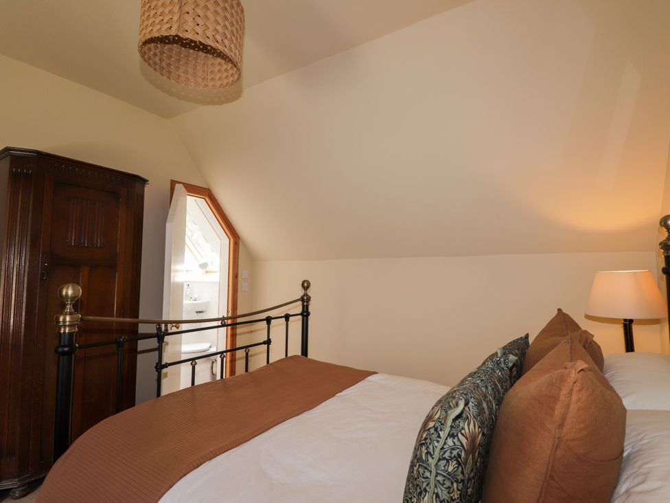 A bedroom with a bed, wardrobe and lamp at Gairnshiel School House near Ballater