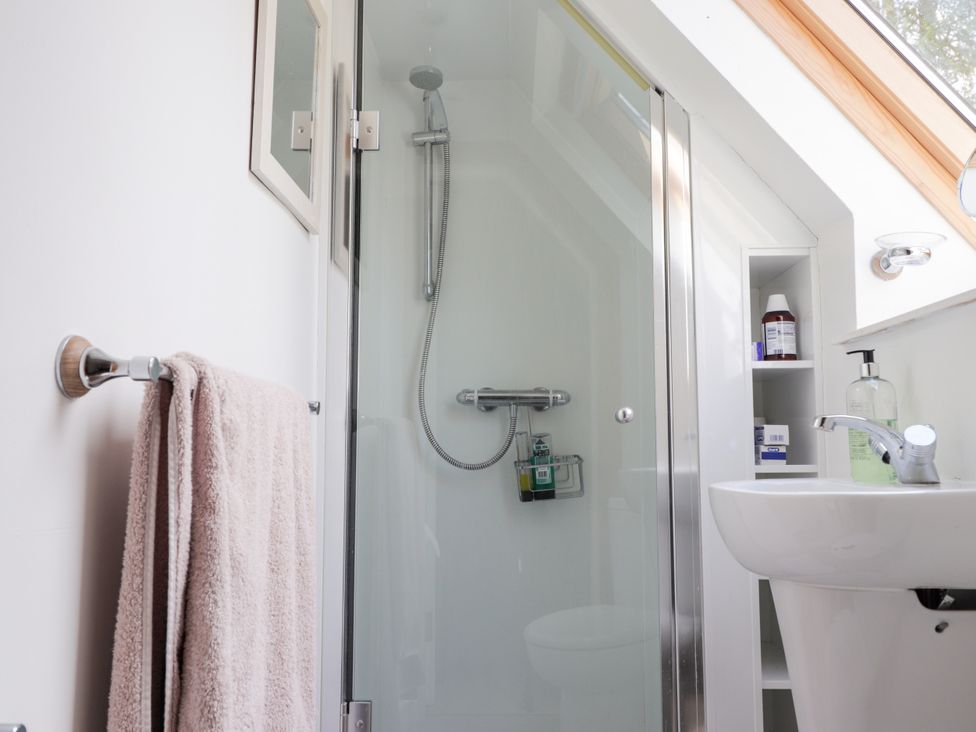 A bathroom featuring a shower, sink and shelf at Gairnshiel School House near Ballater