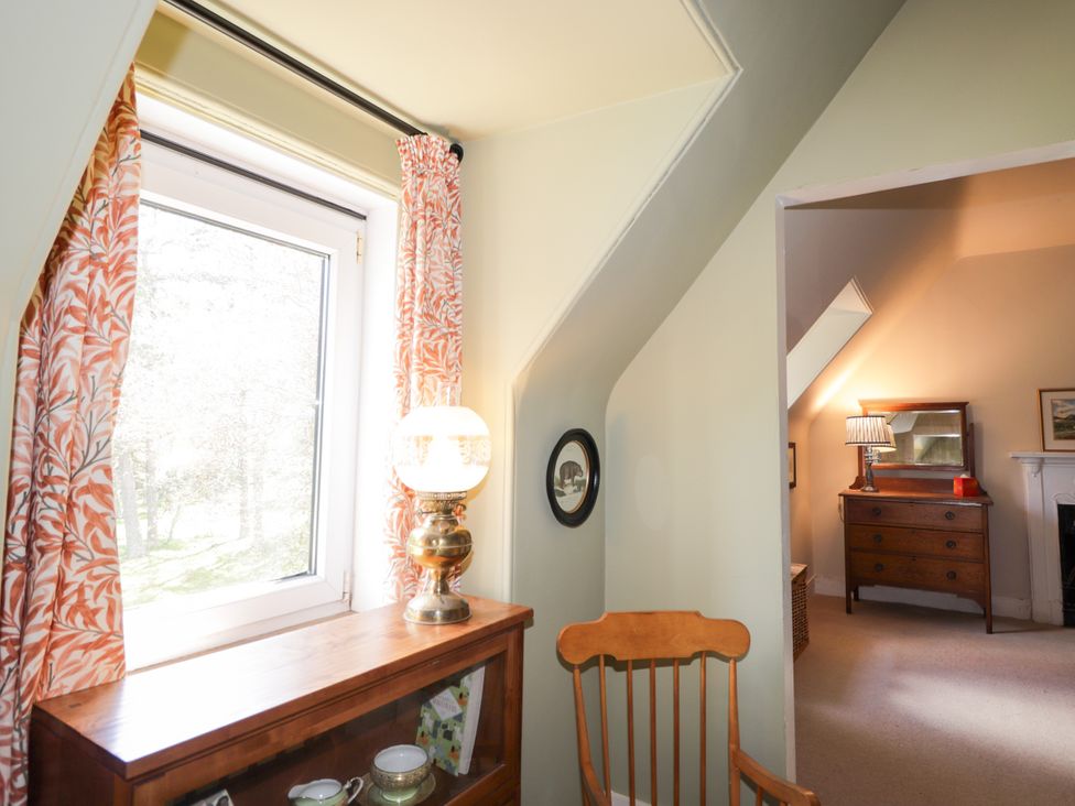 A landing area with a window and furniture at Gairnshiel School House near Ballater