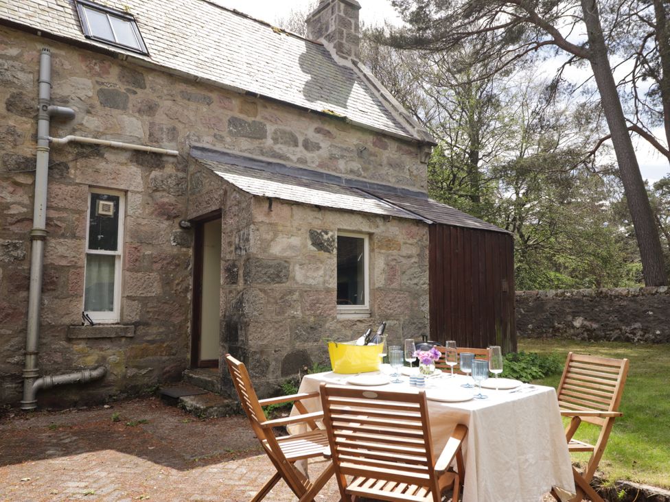 A table set with chairs near a stone building at Gairnshiel School House near Ballater