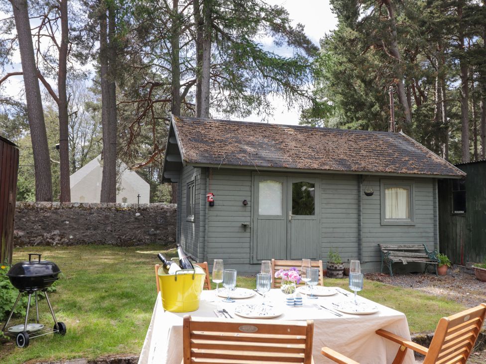 A garden with a table and chairs set near a shed at Gairnshiel School House near Ballater