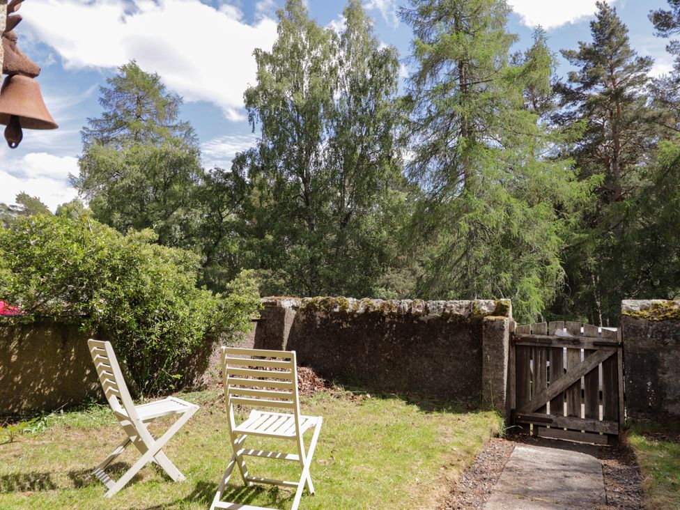 A garden with chairs and a gate at Gairnshiel School House near Ballater