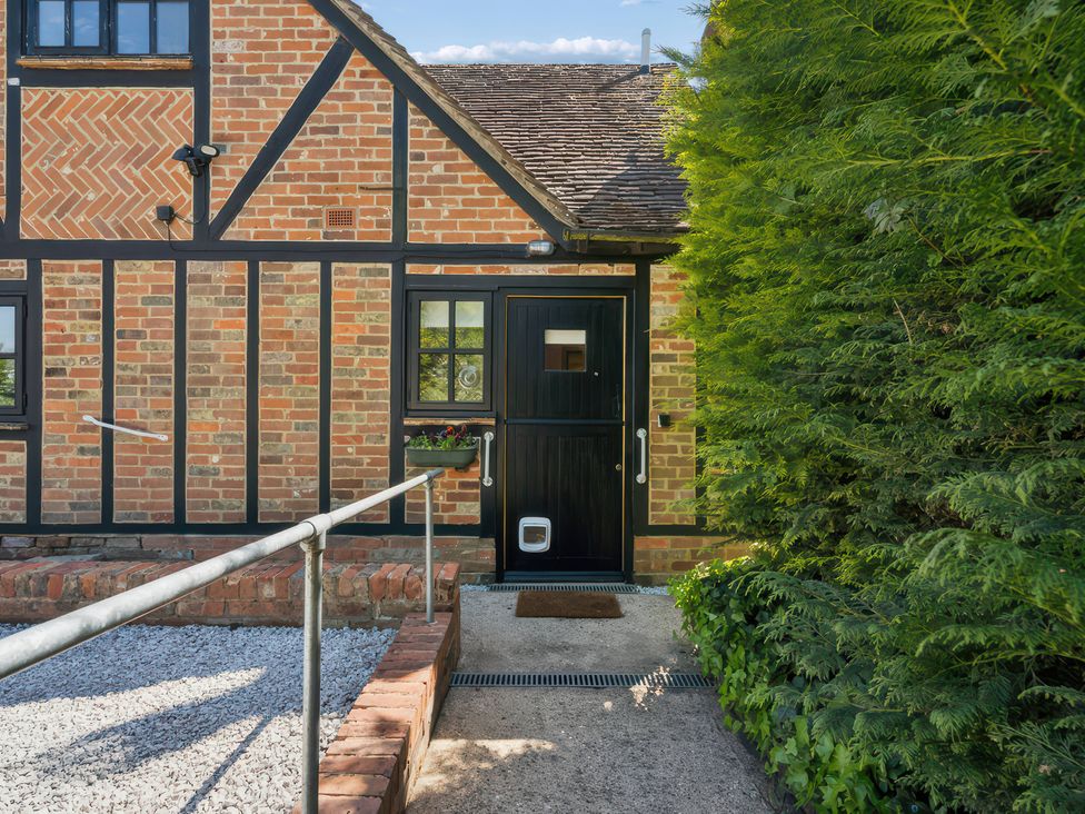 An entrance with a black door and brick wall at 5 Acres Cottage Rickmansworth