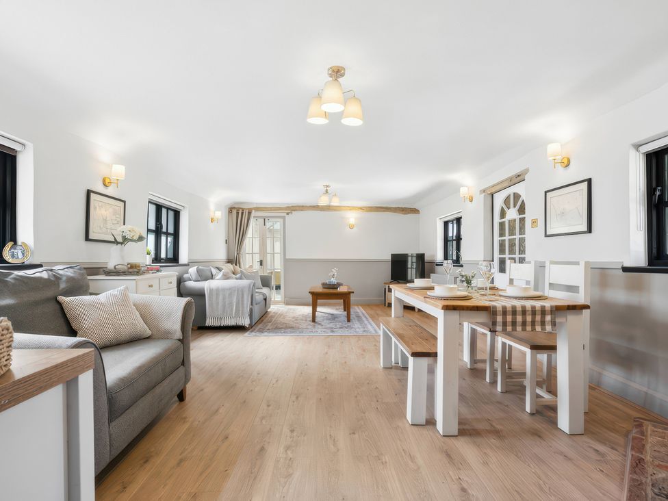 A living room with a dining area and furniture at 5 Acres Cottage in Rickmansworth