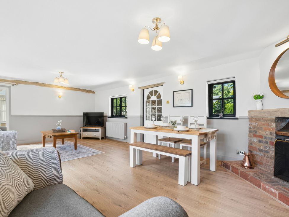 A living room with a dining area and fireplace at 5 Acres Cottage in Rickmansworth