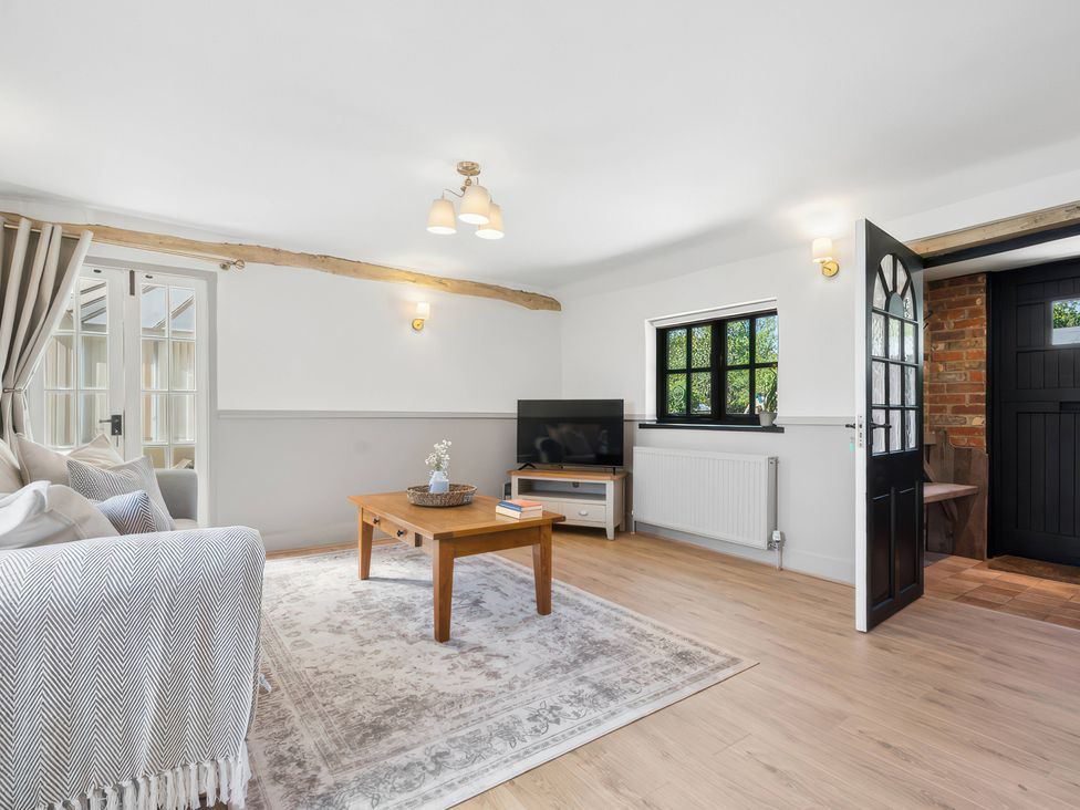 A living room with a sofa and television at 5 Acres Cottage in Rickmansworth
