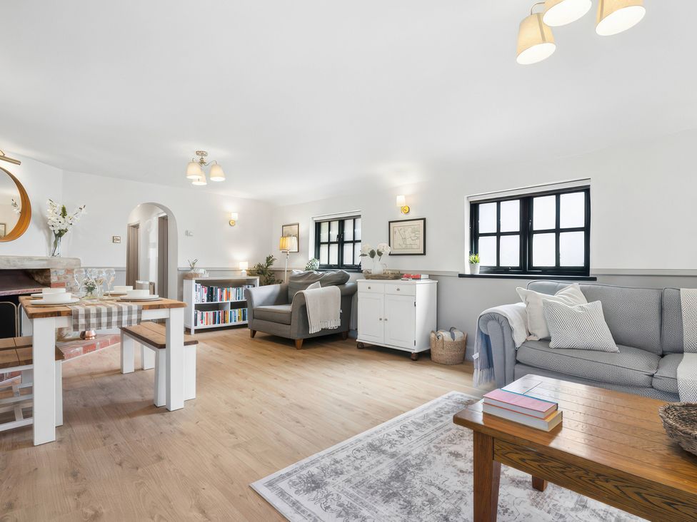 A living room with sofa and dining table at 5 Acres Cottage in Rickmansworth