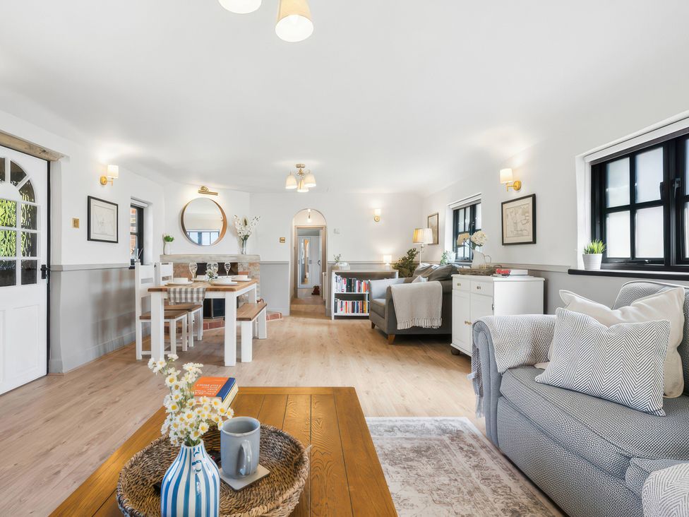 A living room with a sofa and dining area at 5 Acres Cottage in Rickmansworth