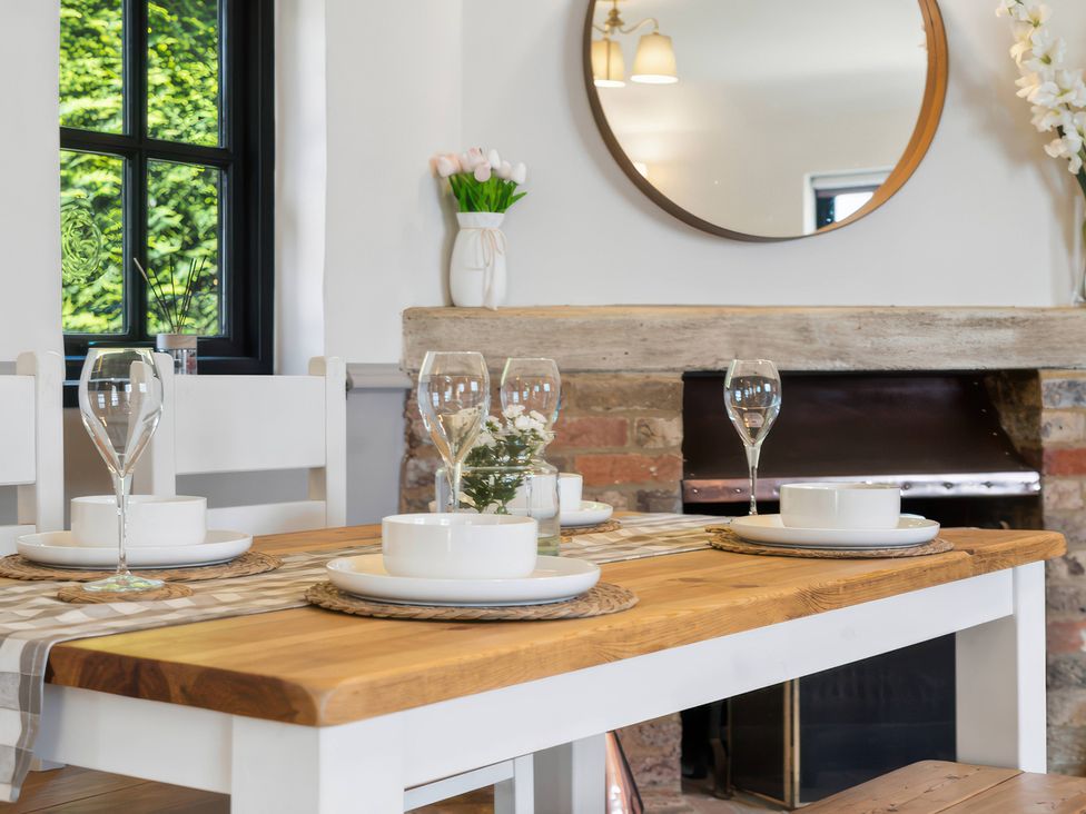 A dining room with a table set for meals at 5 Acres Cottage in Rickmansworth