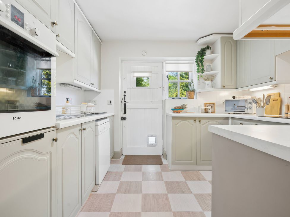 A kitchen with appliances and a door leading outside at 5 Acres Cottage in Rickmansworth