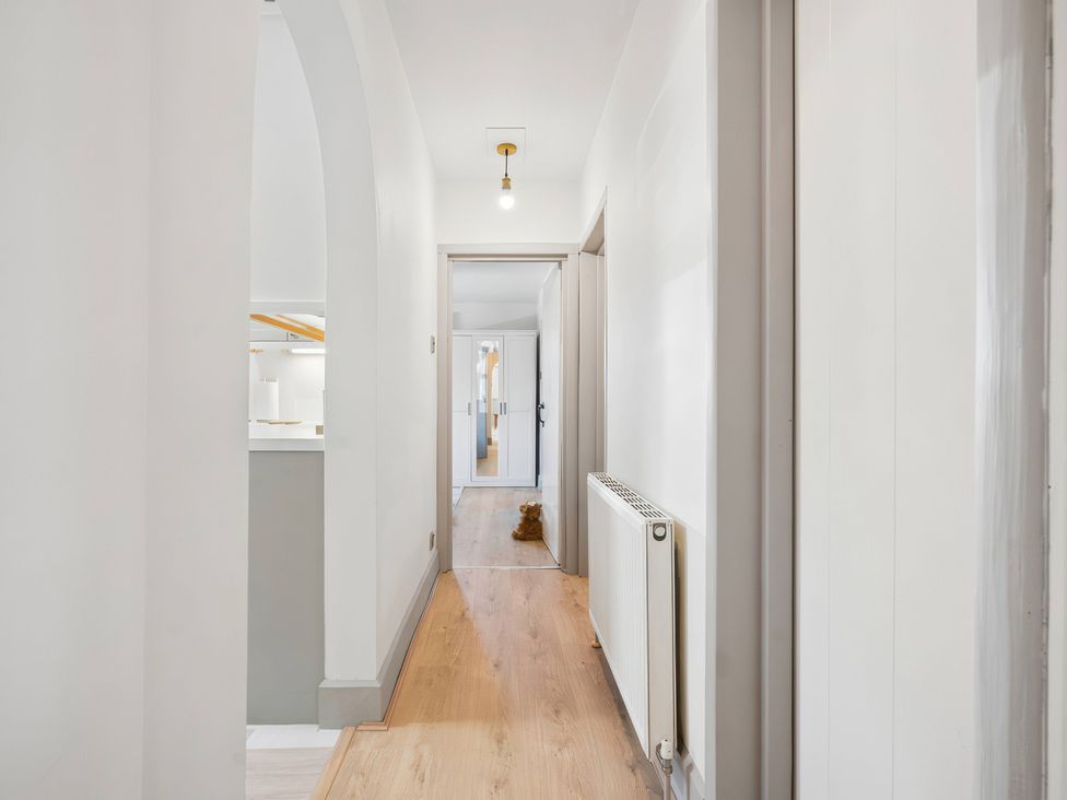 A hallway with a light fixture and a radiator at 5 Acres Cottage in Rickmansworth