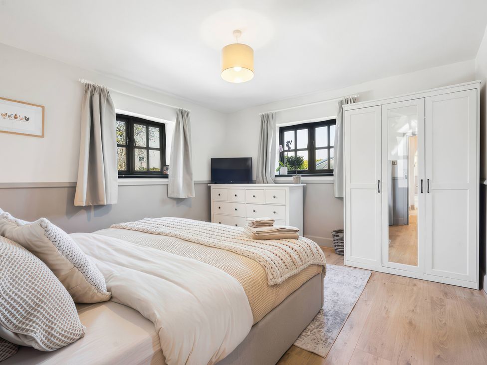 A bedroom with a bed and television at 5 Acres Cottage in Rickmansworth