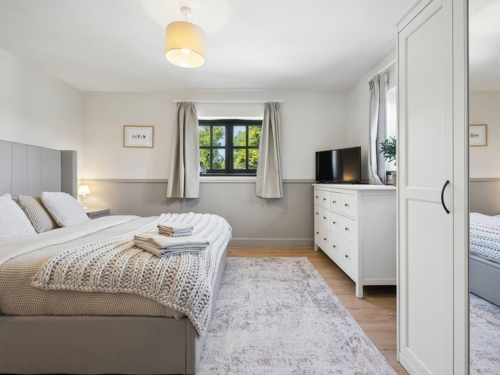 A bedroom with a bed and a television at 5 Acres Cottage in Rickmansworth