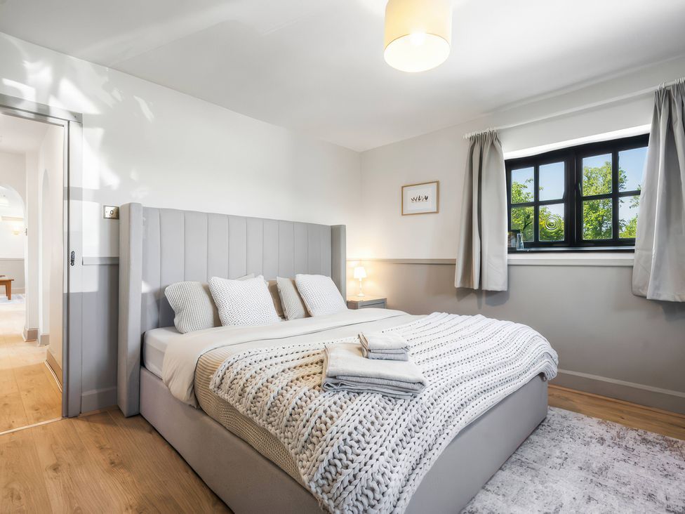 A bedroom with a bed and window at 5 Acres Cottage in Rickmansworth