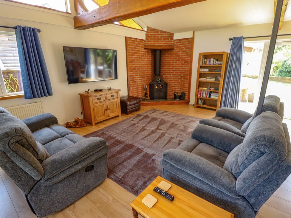 A living room with a sofa, television, and fireplace at 80 Pentney Lakes, Pentney near King's Lynn