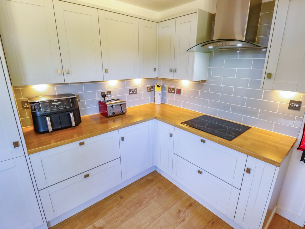 A kitchen with appliances and wooden countertop at 80 Pentney Lakes, Pentney near King's Lynn