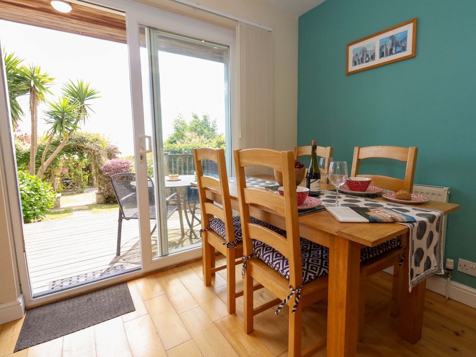 A dining room with a table and chairs at Little Gem in Weymouth
