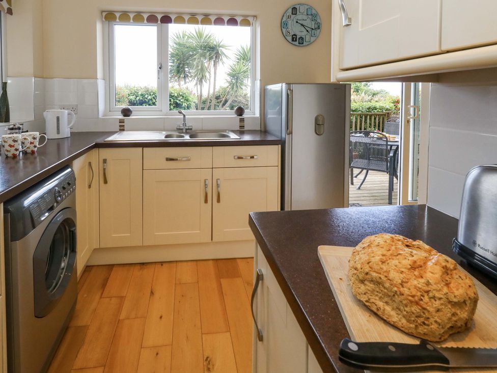 A kitchen with a sink and washing machine at Little Gem in Weymouth