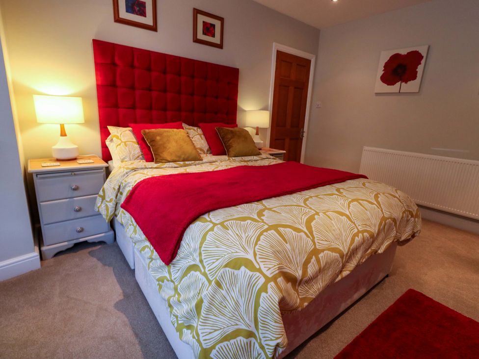 A bedroom with a bed and bedside table at Little Gem in Weymouth