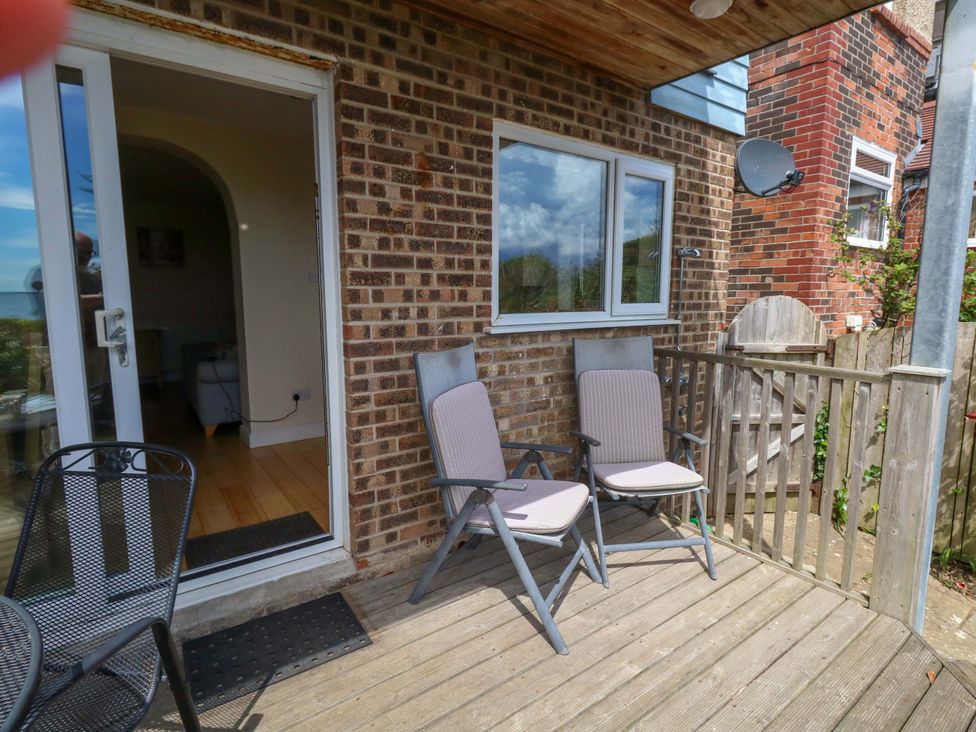 A deck with chairs and door at Little Gem in Weymouth