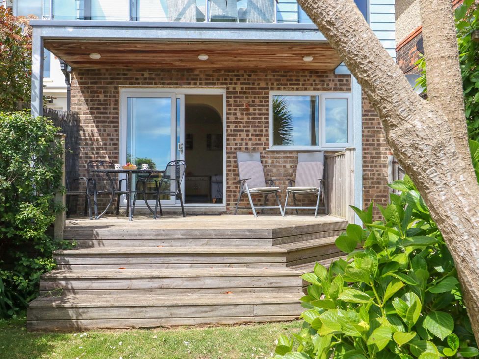 A patio area with a table and chairs at Little Gem in Weymouth