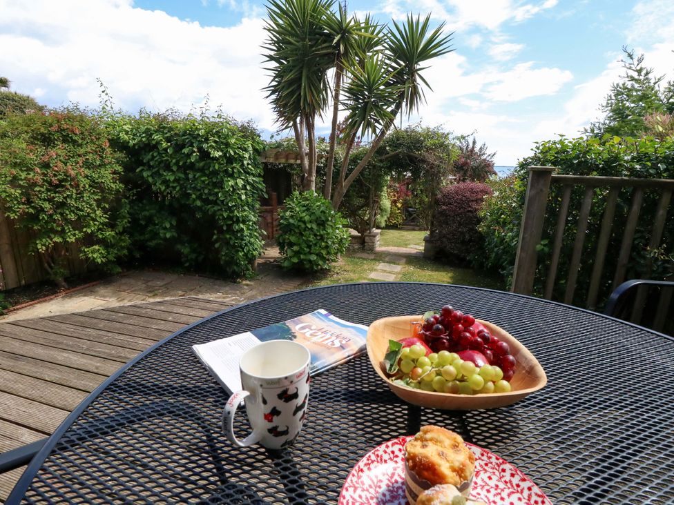A garden scene with a table set for refreshments at Little Gem in Weymouth