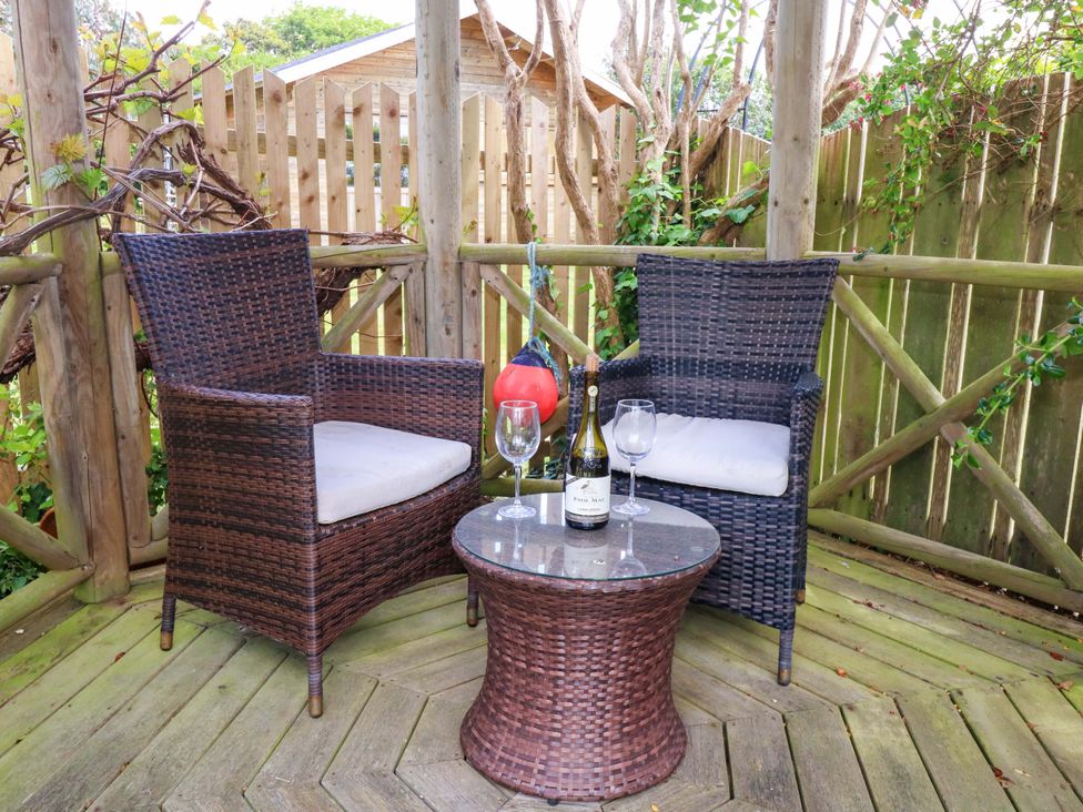 An outdoor seating area with two chairs and a table at Little Gem in Weymouth