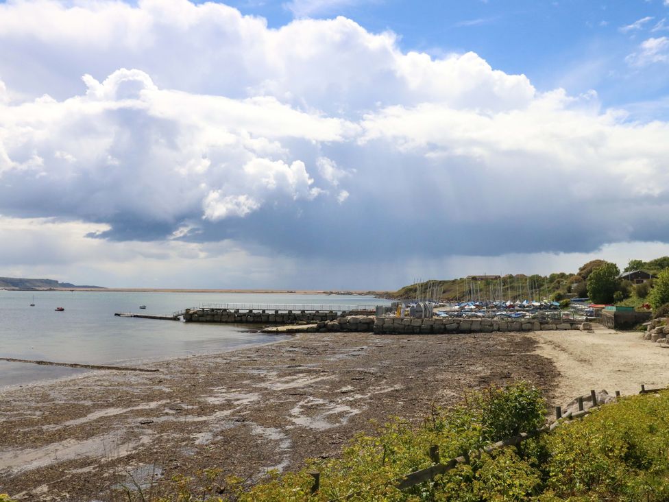 A view of the shoreline with a pier and boats at Little Gem in Weymouth
