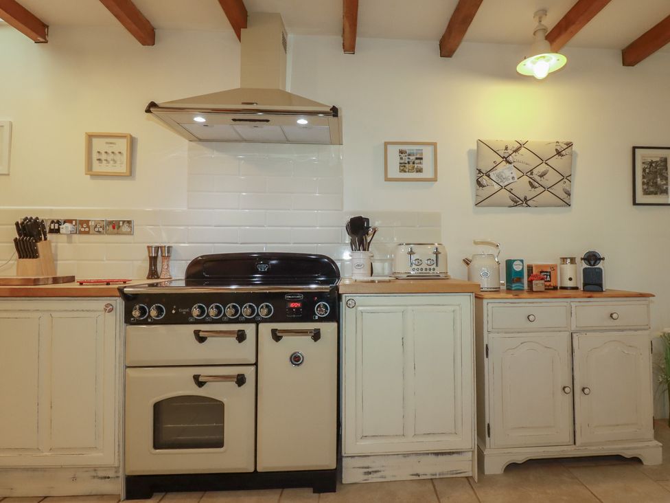 A kitchen with a range cooker and cupboards at Cider Cottage 