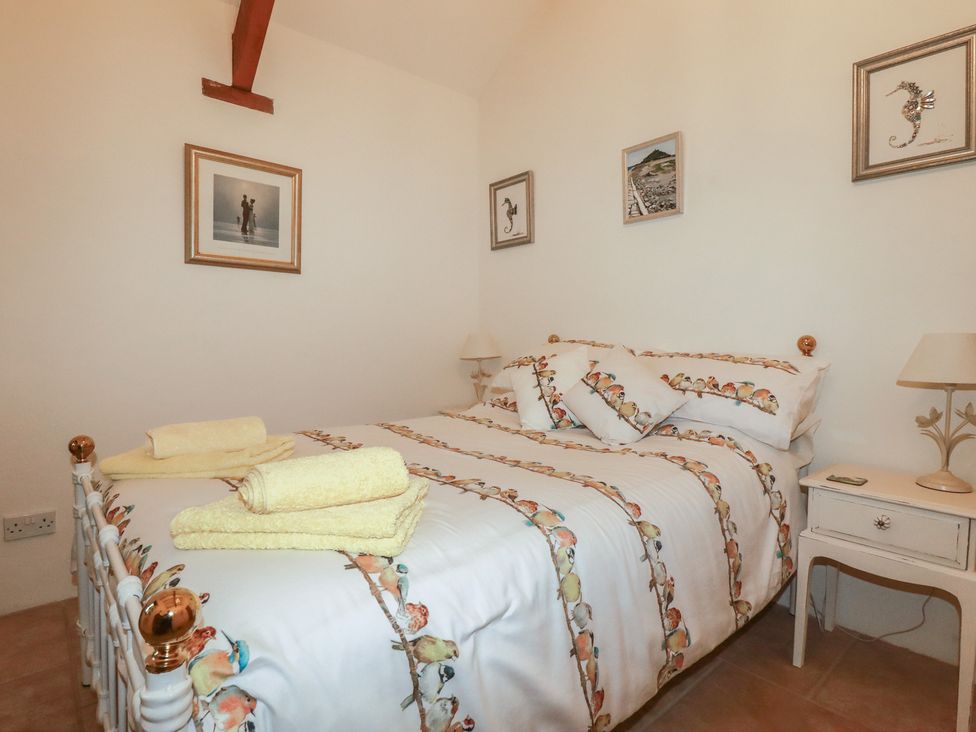 A bedroom with a bed and bedside table at Cider Cottage