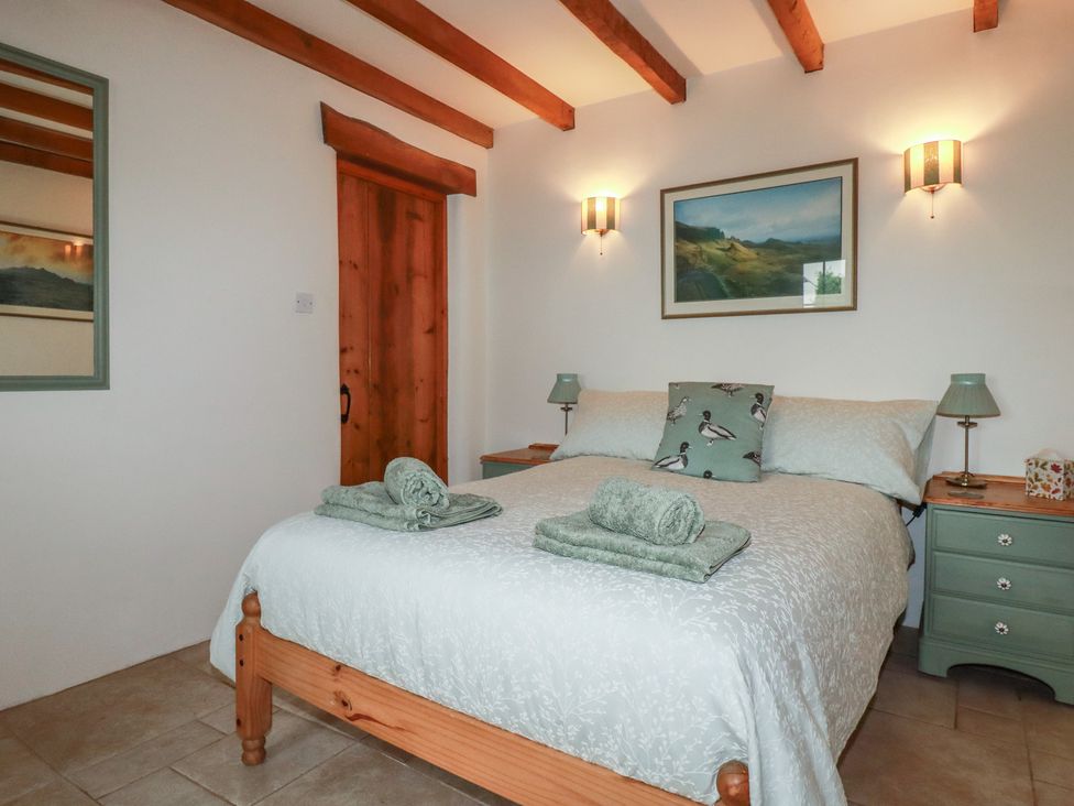 A bedroom with a bed and bedside tables at Cider Cottage