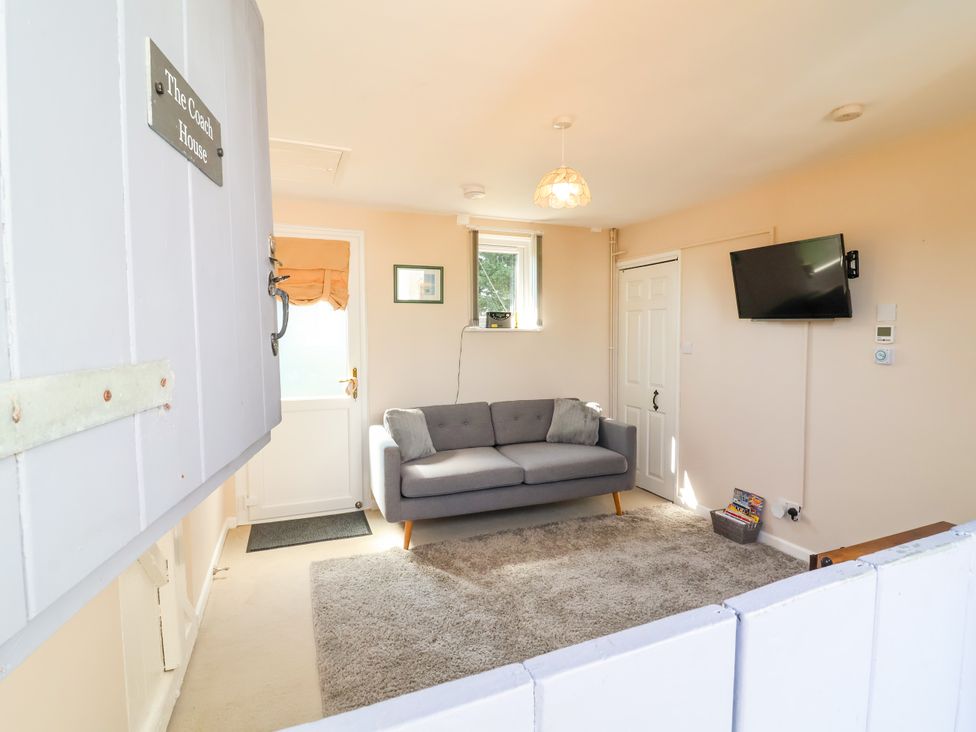 A living room with a sofa and television at Coach House Highampton near Black Torrington