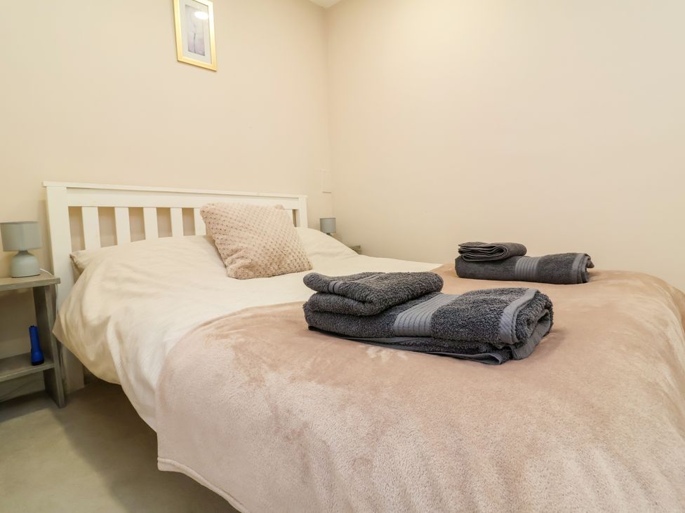 A bedroom with a bed and towels at Coach House Highampton near Black Torrington